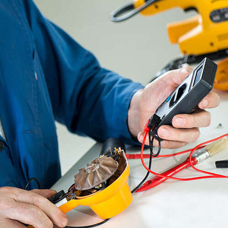 Mann mit Messgerät prüft elektronische Bauteile