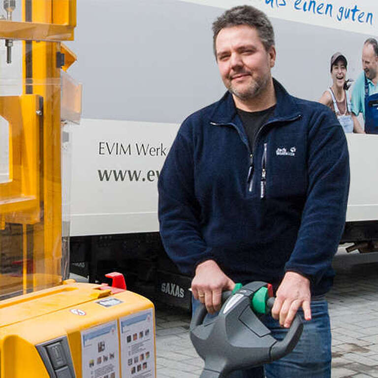 Mann mit Gabelstapler belädt Lastwagen